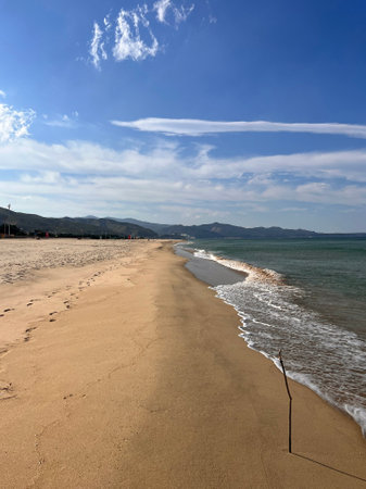 Beach and blue sky with clouds in Alghero, Sardiniaの写真素材