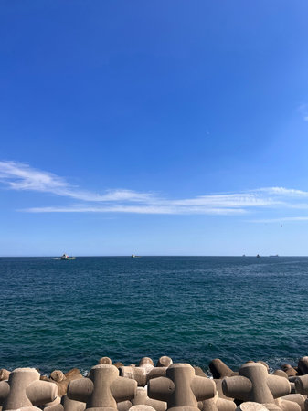 Seascape with blue sky, sea and stone breakwater.の写真素材