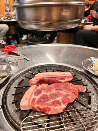 Raw pork on the grill with hot pot in the background, Japanの写真素材