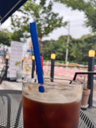 Iced coffee on the table in the cafe with blurred background.