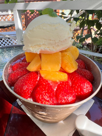 Strawberry ice cream in a bowl with fresh strawberries and mangoの写真素材