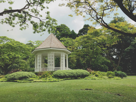Gazebo in the garden with green grass and trees.の写真素材