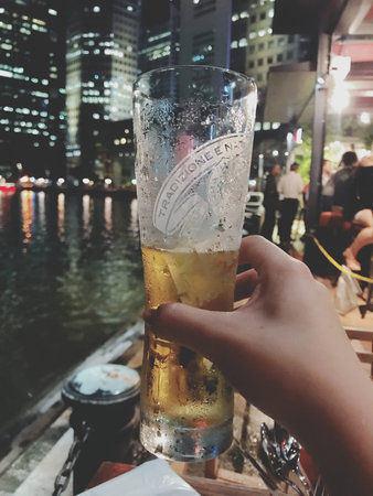 Hands holding a pint of beer on a boat in Hong Kong