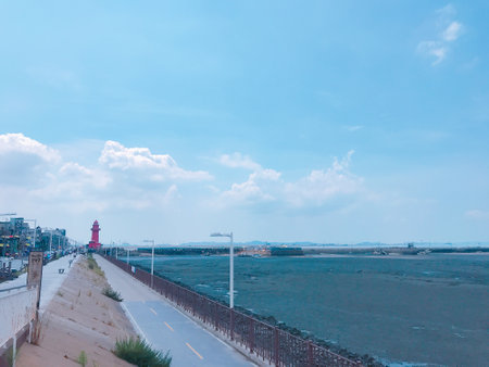 Seaside promenade and lighthouse with blue sky background.の写真素材