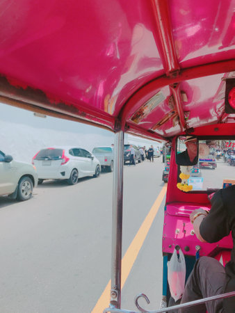 Unidentified people traveling by tuk tuk in Bangkok, Thailand.の写真素材