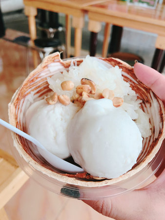 Thai style ice cream with coconut milk and nuts in cup.