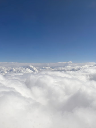 Cloudscape, view from airplane window with blue sky and white clouds
