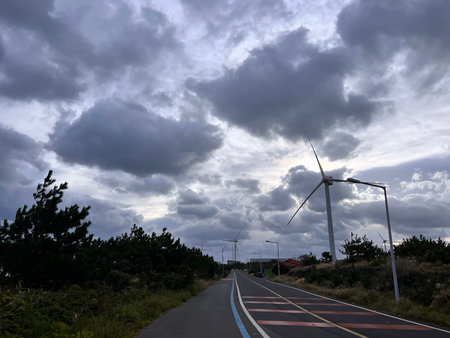 wind turbines on the road in the evening with stormy sky.