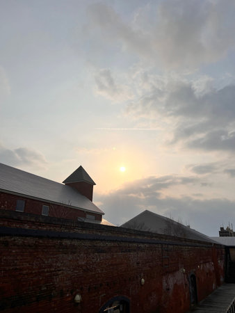 Old red brick wall and blue sky with white clouds at sunset.の写真素材