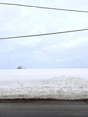 snow-covered road in the countryside, closeup of photo