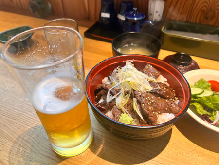 Japanese cuisine. A glass of beer and a plate of beef.の写真素材