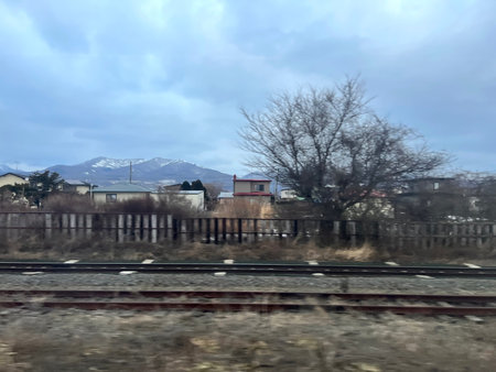 View from the car window on the train tracks and mountains in background