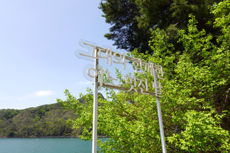 Signpost on the beach of the lake in the park on a sunny dayの写真素材