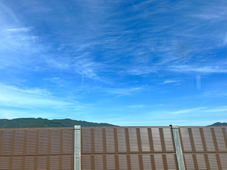 Wooden fence with blue sky and cloud background. Perspective view.の写真素材
