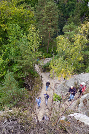 Tourists walk along the steep slope of the mountain in the forest.の写真素材