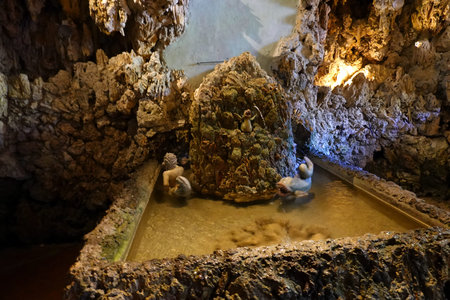 Interior view of a cave with people bathing in a hot spring