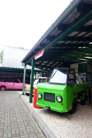 Vintage green car parked at the gas station on a sunny dayの写真素材