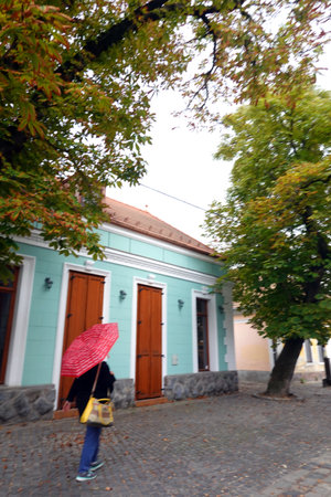 A girl with an umbrella walks along the street of the old town.の写真素材