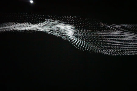 Sound waves in the dark, with lights and spotlights in the background