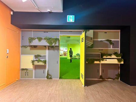 Interior of a modern office hall with green and yellow doors.