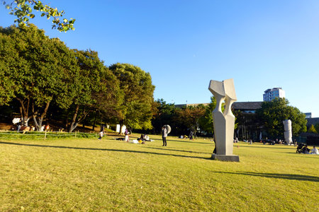 Unidentified people relax on the lawn in Tokyo, Japanの写真素材