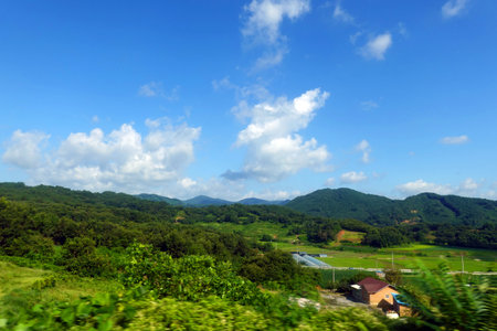 green mountain under blue sky and white clouds in the countryside of Thailandの写真素材
