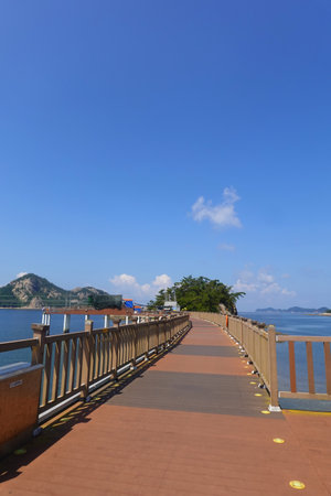 Wooden walkway to the sea with blue sky and clouds backgroundの写真素材
