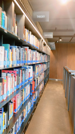 Blurred image of bookshelf in library for background usage.