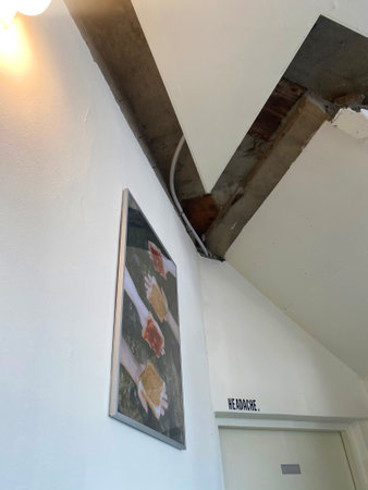 Ceiling of a building with a white wall and a sign.の写真素材