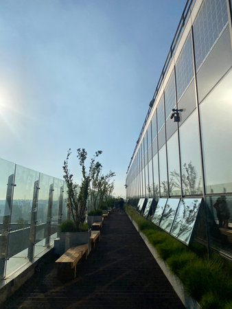 Modern office building exterior with glass wall and blue sky in the background