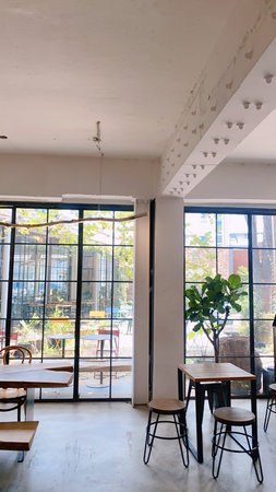 Interior of a modern cafe with tables and chairs. Nobody inside