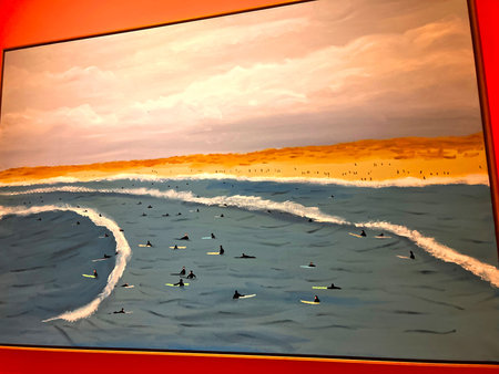 Surfers on the beach at sunset. Photo in the frame.