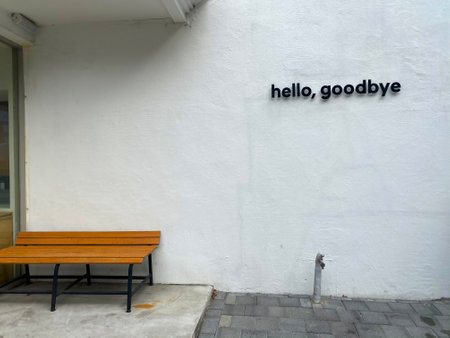 Restaurant sign on a white wall with a wooden bench.の写真素材