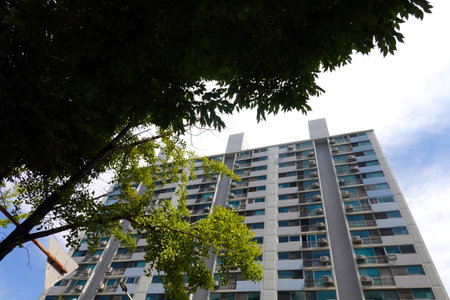 Residential building with green trees and blue sky in the background.