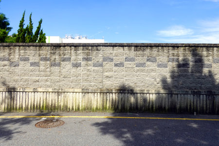 Stone wall in the street with blue sky and white cloud background.の写真素材