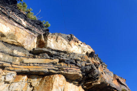 Rocky cliff against the blue sky. Natural background. Landscape.