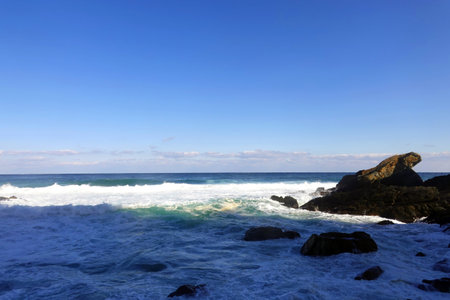 Beautiful seascape with waves on the rocks and blue sky