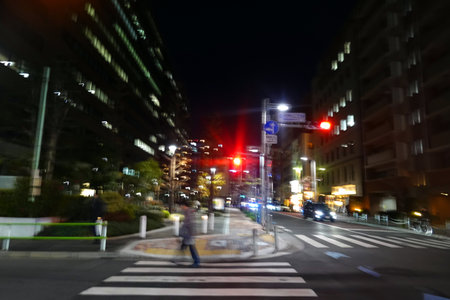 Unidentified people cross the street in Tokyo at night.の写真素材
