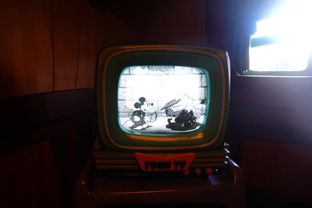 Vintage TV set on a wooden table in a dark room.の写真素材