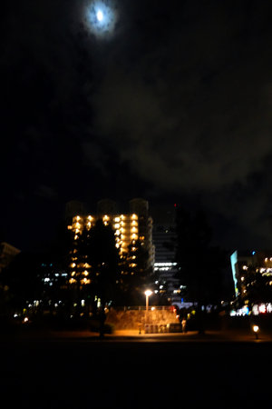 Night cityscape with a full moon in the sky. Blurred backgroundの写真素材