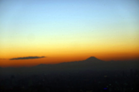 blur image of sunset in the city with silhouette of mountain background.の写真素材