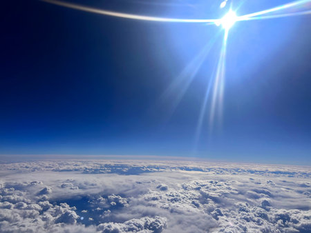 Beautiful view above clouds on blue sky with sunbeams.