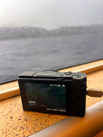 Close up of a camera on a train window with raindrops.