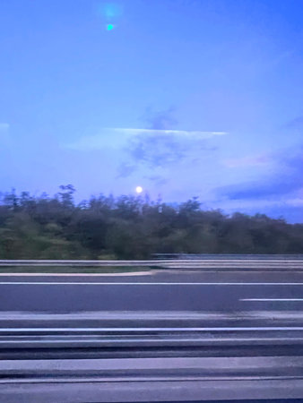 Driving on highway in the evening. Road through the forest.