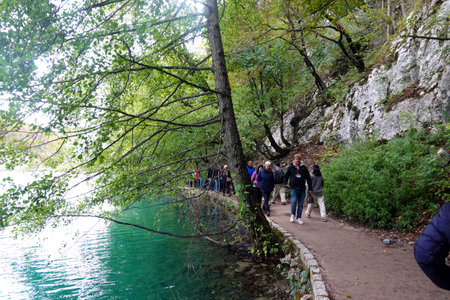 Tourists walk along the banks of the Plitvice Lakes in Croatiaの写真素材