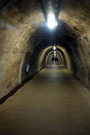 Underground tunnel with light at the end of the tunnel. Blurred background.の写真素材