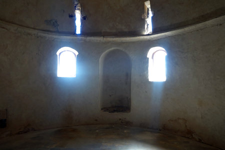 The interior of an old church with two windows and a white wallの写真素材