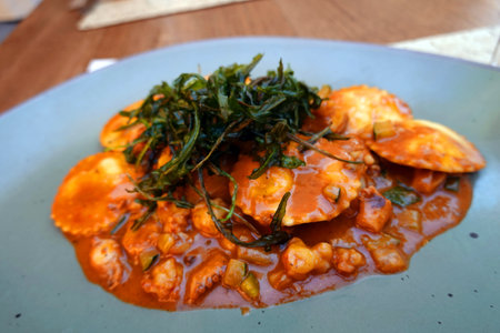 Crispy fried squid in tomato sauce with seaweed on plateの写真素材