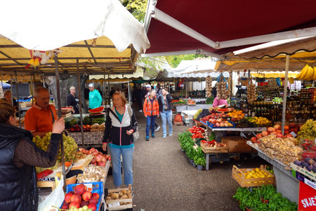 Unidentified people buying fruits and vegetables at a market in Zurich. Zurich is the largest city in Switzerland and the capital of the Swiss canton of Zurich.の写真素材