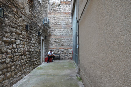 Man sitting on a bench in an alley in the old town of Rovinj, Croatia